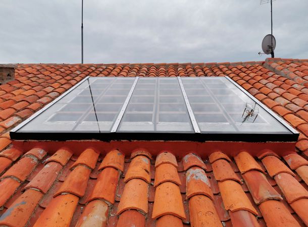 imagen de una claraboya de cristal en un tejado de una casa para que entre la luz y la ilumine por dentro