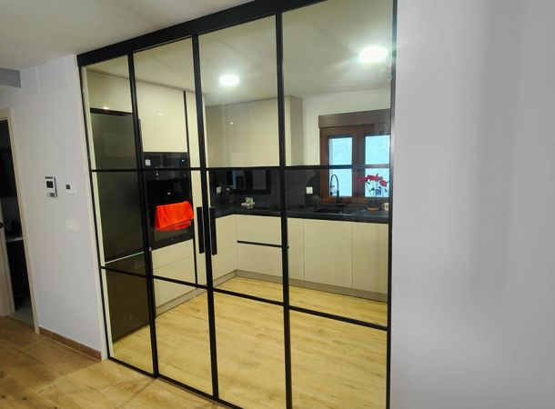 imagen de cerramiento de cristal que separa la cocina del comedor dejando pasa bastante luz